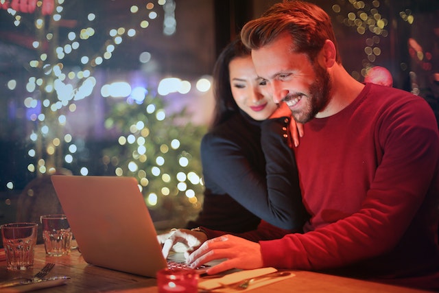 due persone sorridenti davanti a un computer portatile