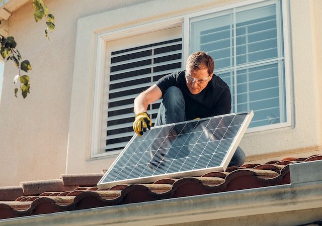 un uomo che sta installando i pannelli fotovoltaici
