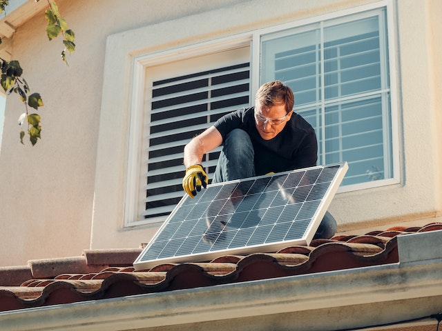 un uomo che sta installando i pannelli fotovoltaici